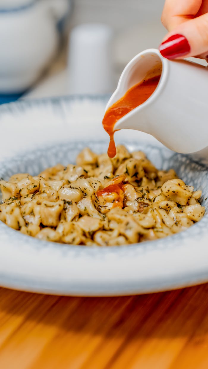 Close-up of Turkish manti being served with traditional sauce in Niğde, Türkiye.